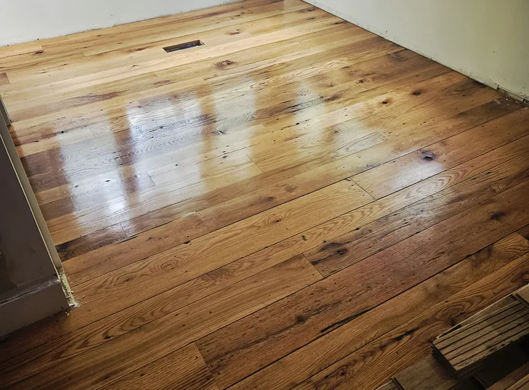 Newly laid hardwood flooring running through a finished room