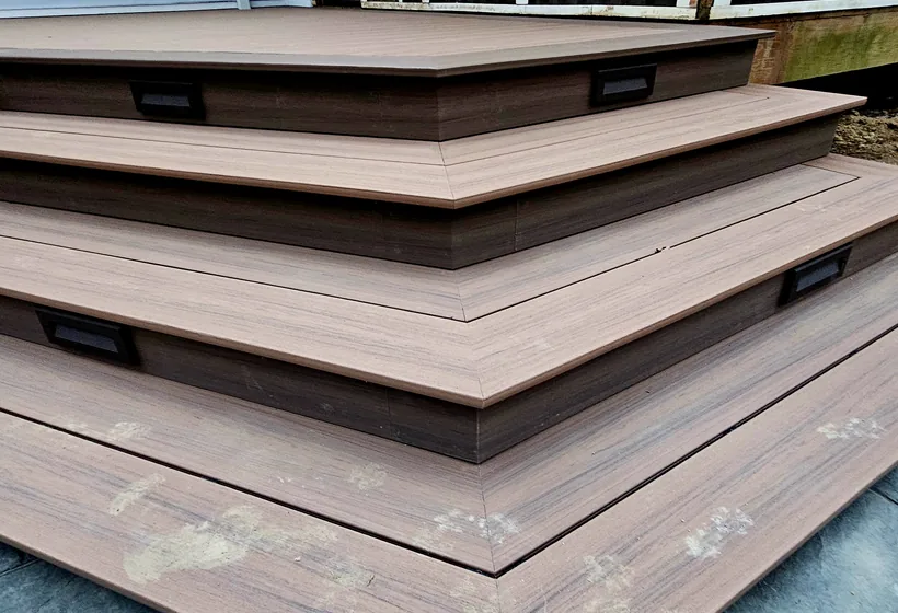 Composite deck with cascading corner stairs and recessed step lighting