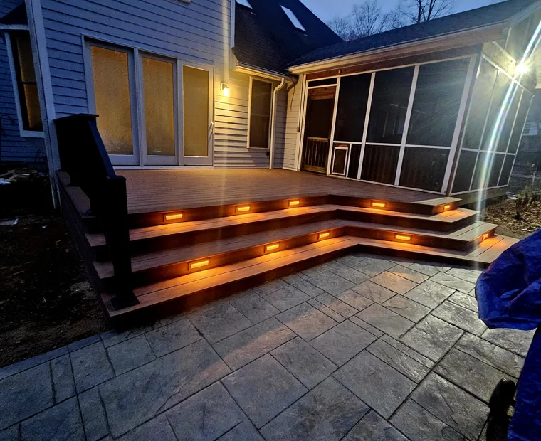 Finished composite deck lit at dusk with illuminated stair treads