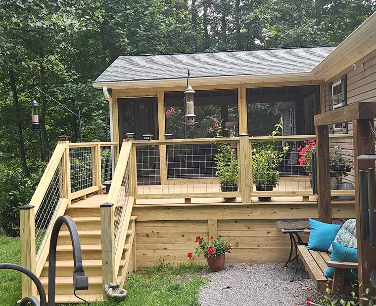 Screened porch and deck with cable railing and planted borders