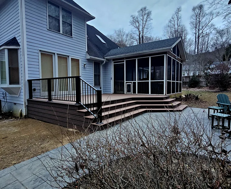 Rear deck and screened porch with black metal railing