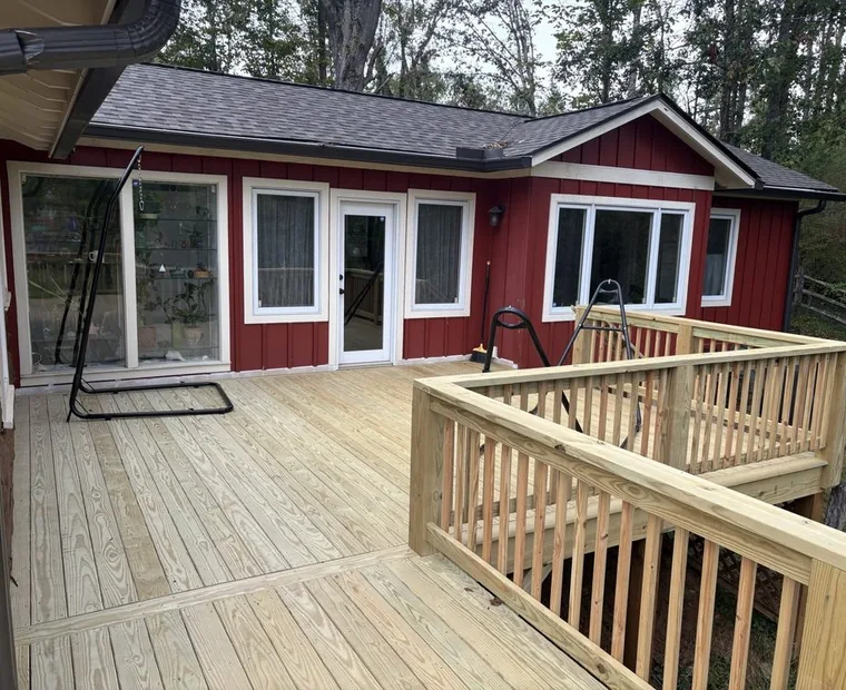Pressure treated deck and railing built onto a red-sided home