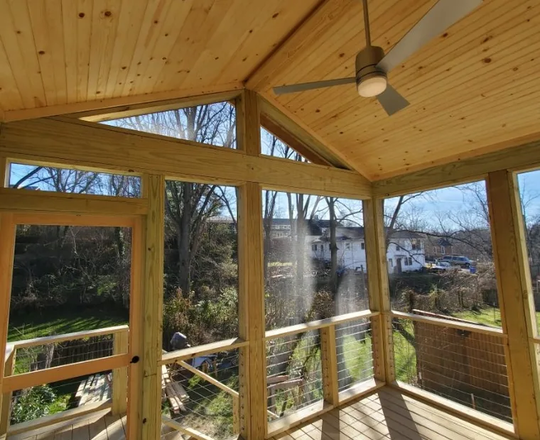 Screened porch interior with a tongue and groove ceiling and fan
